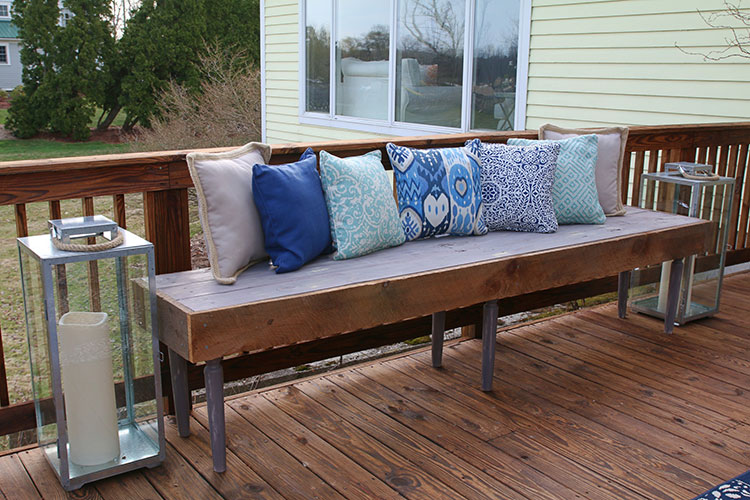 Patio featuring rustic bench with pillows