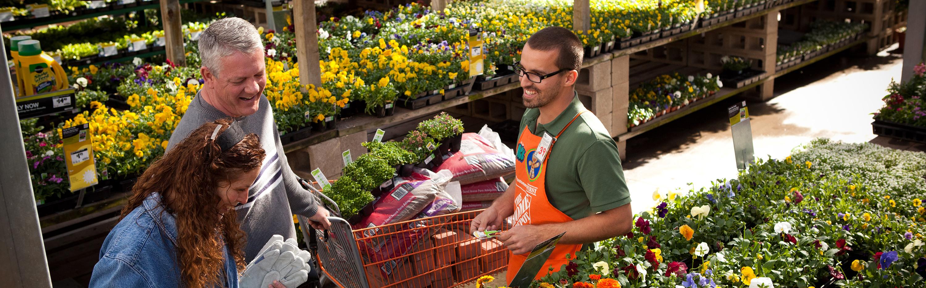 Home Depot associate helps customers in garden department