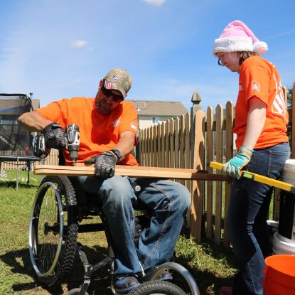 Team Depot volunteers building fence for veteran family