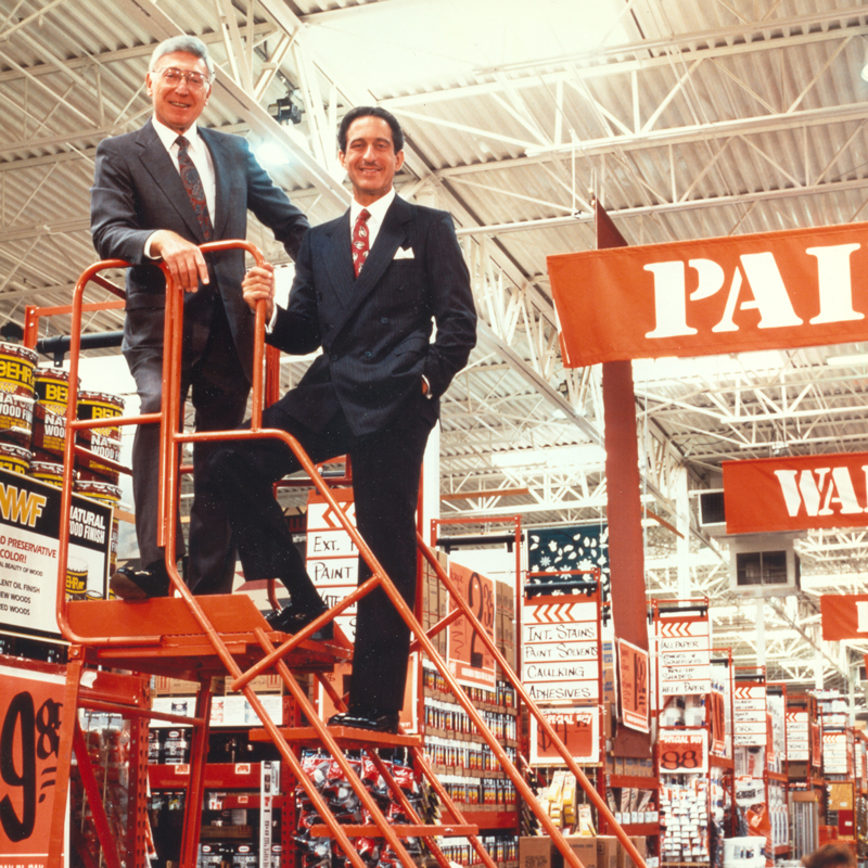 Bernie and Arthur posing on a ladder in a store