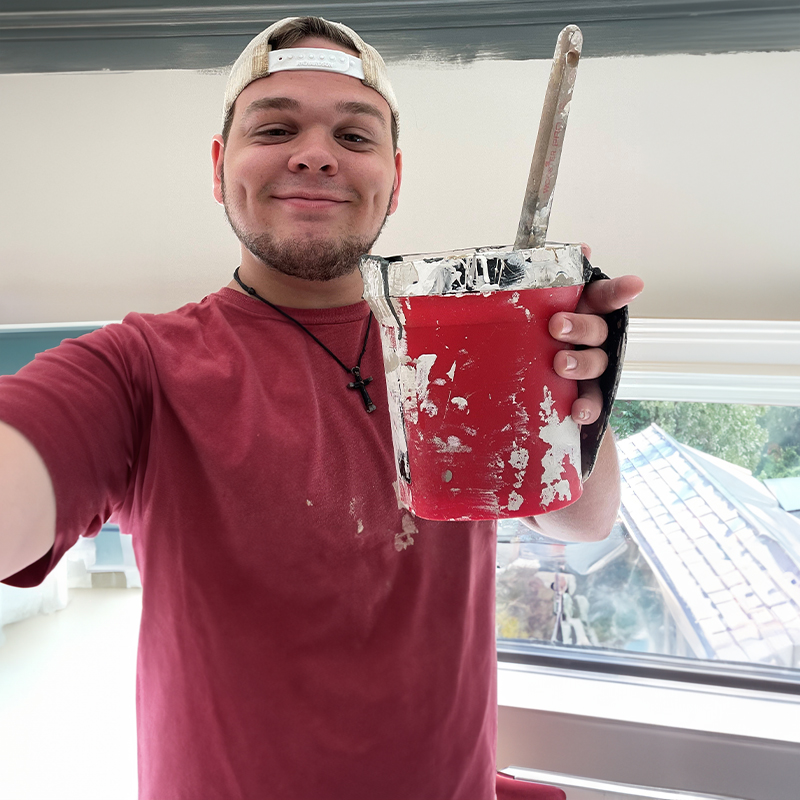 Brandon holding a bucket of paint