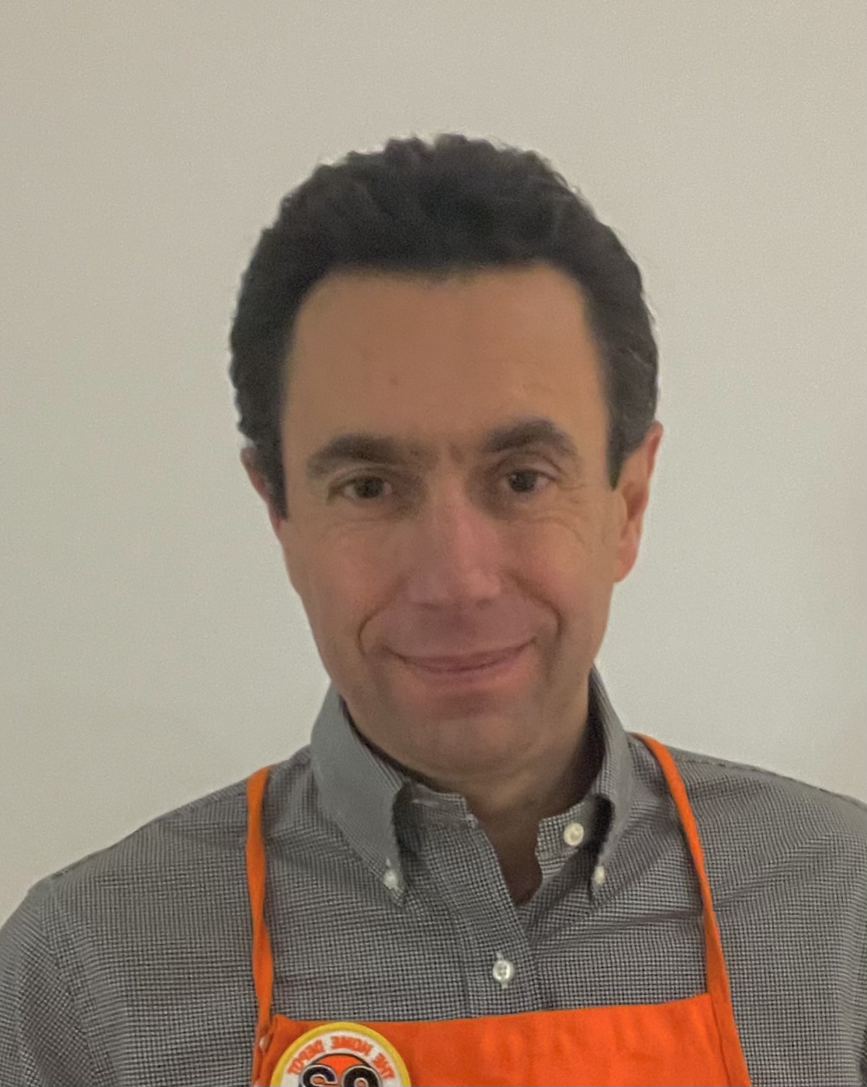 Nicolas Darget headshot in an orange apron