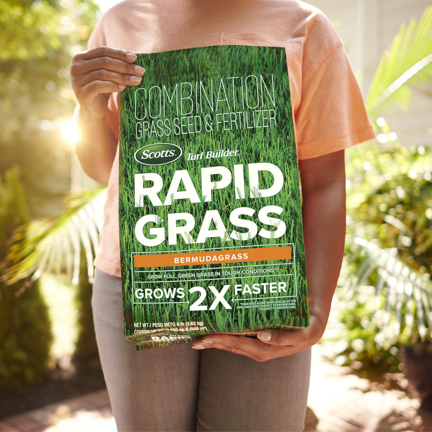 Woman holding Scott's Rapid Grass seed and fertilizer