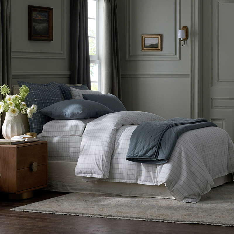 The company store’s collaboration with Stoffer Home bedding on top of a bed