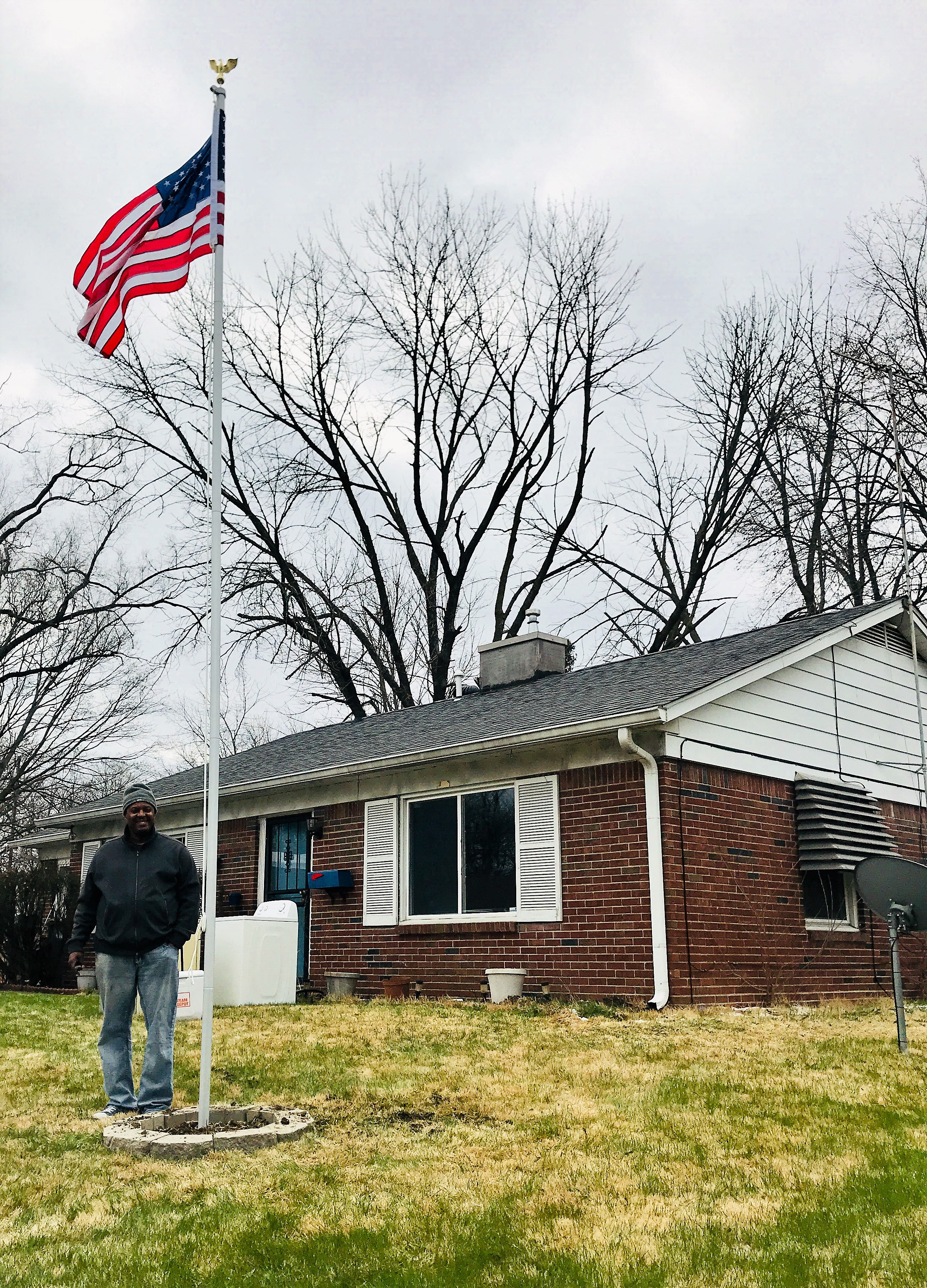 Michael Malone poses in front of home remodeled by Team Depot 