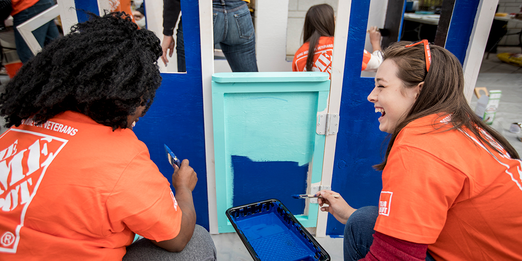 Home Depot volunteers painting playhouses