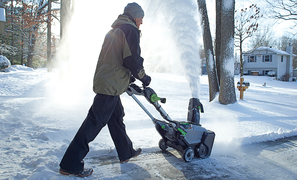 EGO snow blower in use on snow-covered sidewalk