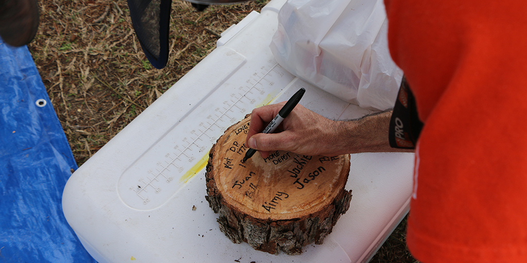 Team Depot volunteer signing tree stump