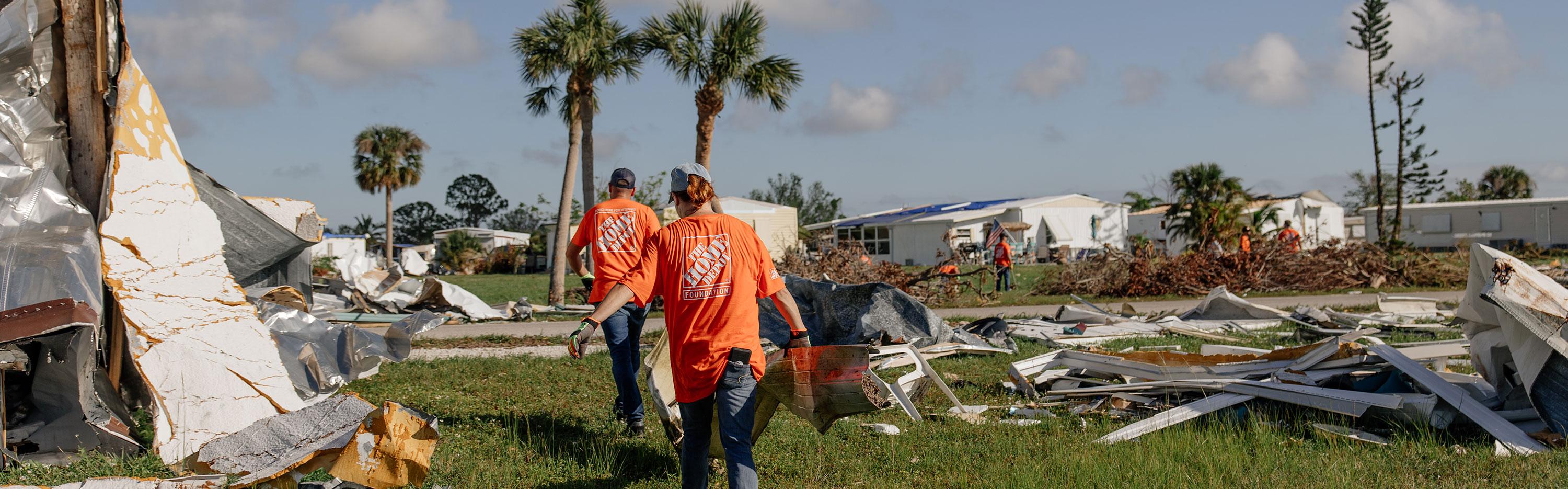 Team Depot volunteers carrying piece of a house through tornado destruction 