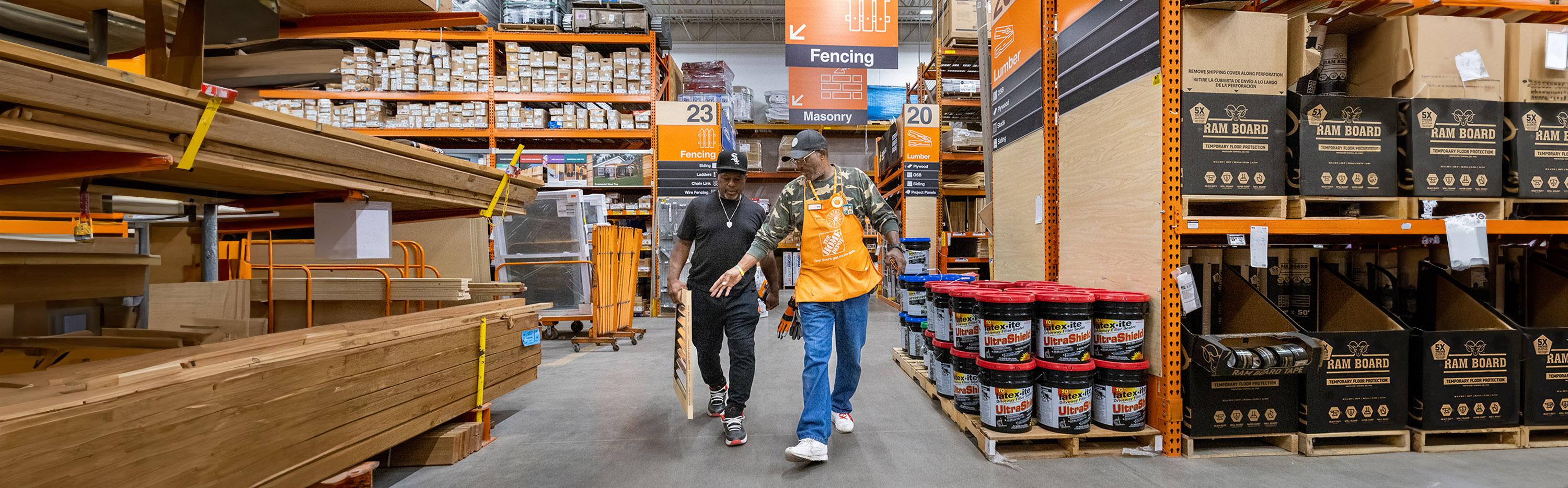 Associate and customer walking an aisle in lumber