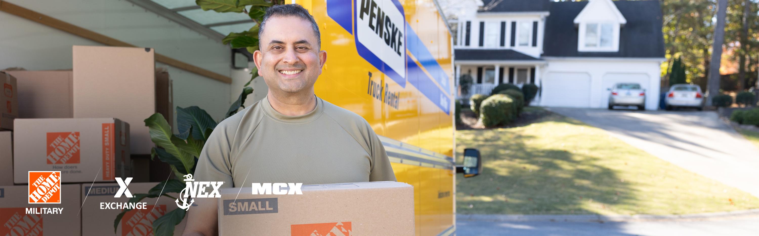 A service member holding a Home Depot moving box