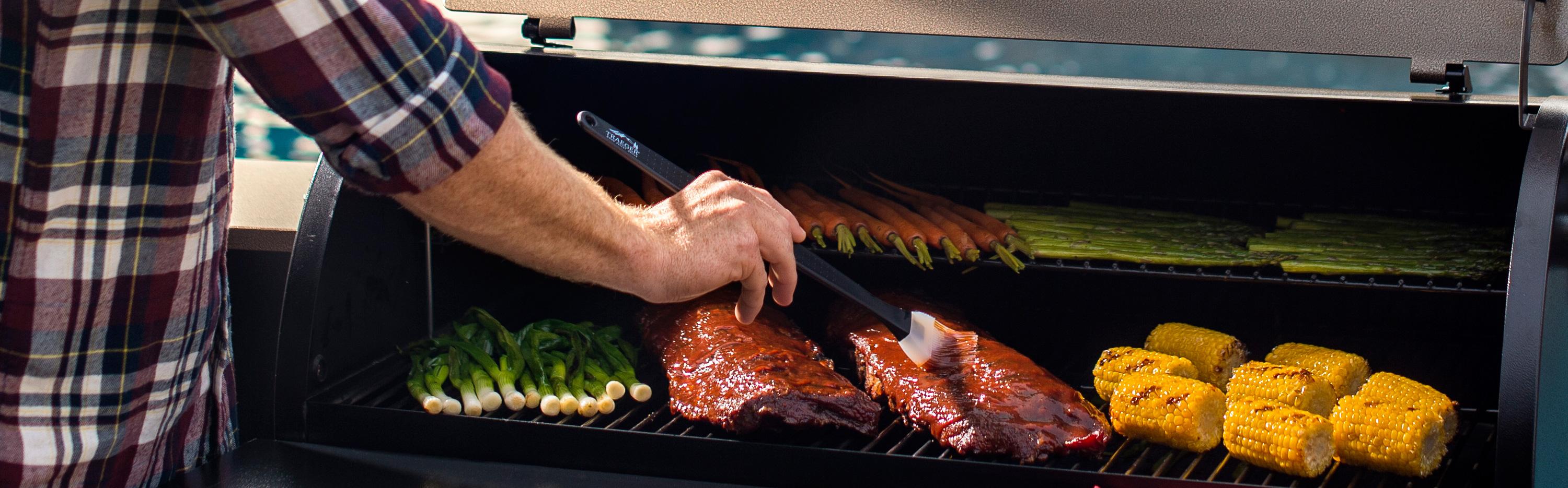 Ribs and vegetables grilling on on a Traeger wood pellet grill