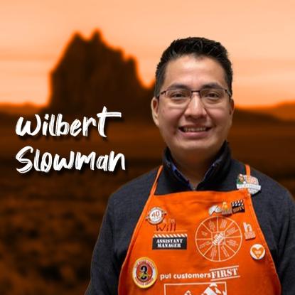Home Depot associate in orange apron standing in front of a Arizona landscape