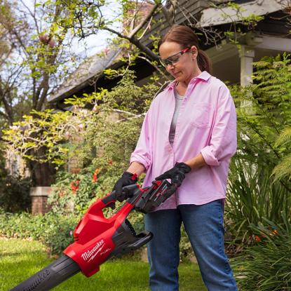 A woman holding a leaf blower