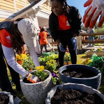 team depot volunteers putting soil and plants into a planter