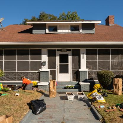 the front of a home with team depot volunteers working out front