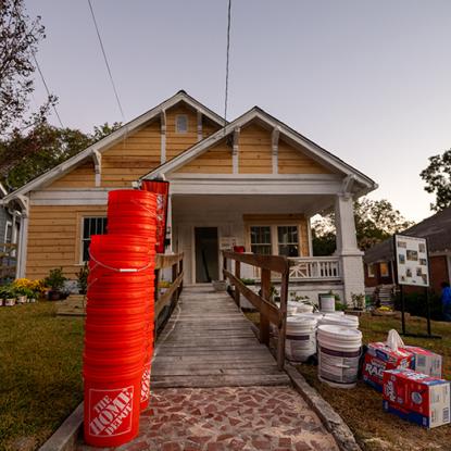 home depot buckets stacked in front of a home