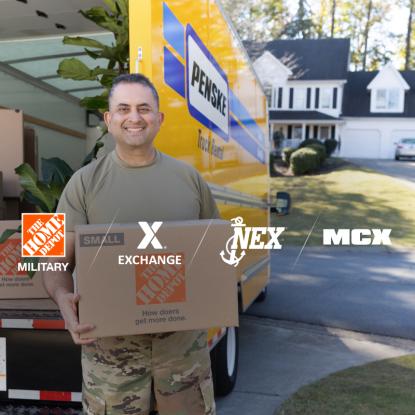 A service member holding a Home Depot moving box