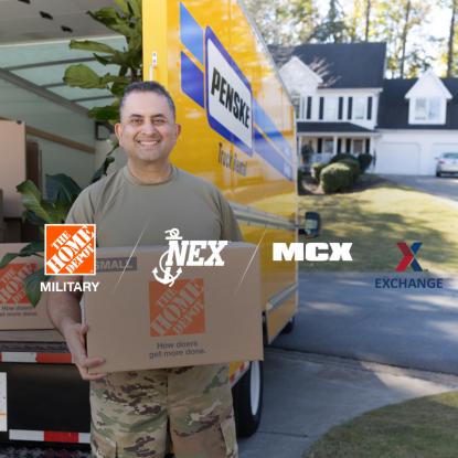 A service member holding a Home Depot moving box