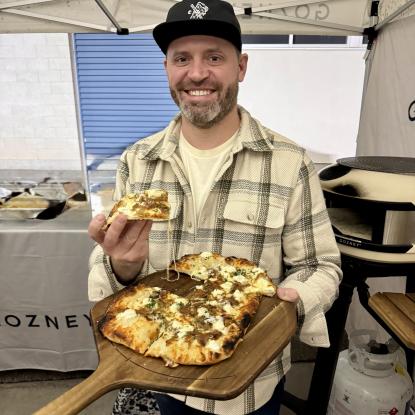 An Image of our grills merchant holding a pizza 