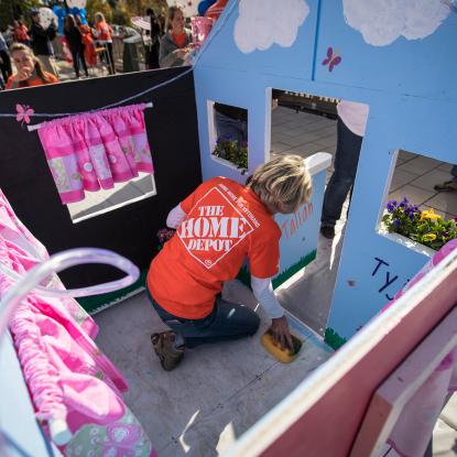 Volunteer works on playhouse