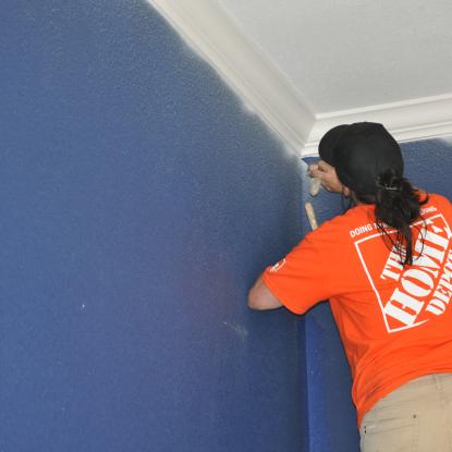 Team Depot volunteer painting a wall