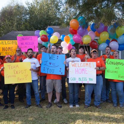 Team Depot volunteers with welcome home signs