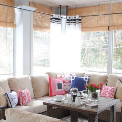 L-shaped couch with bright pillows in screened-in porch