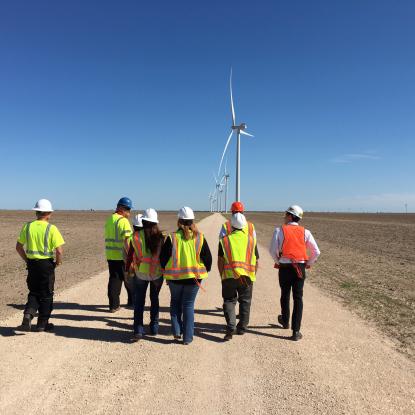 Group walking towards wind turbines in Texas