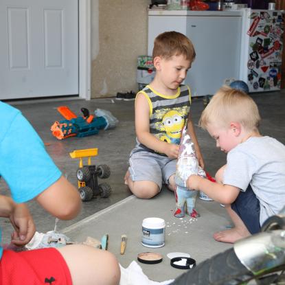 Veteran's sons paint garden gnome during Team Depot Project
