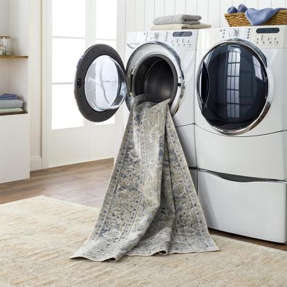 A rug spilling out of a washing machine