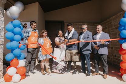 Sgt. Tu’ufuli cutting the ribbon in front of his new home