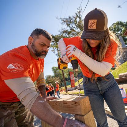 Two team depot volunteers assembling pieces of plywood