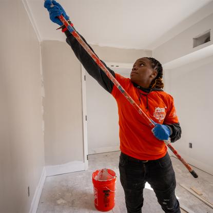 A Team Depot volunteer painting a home