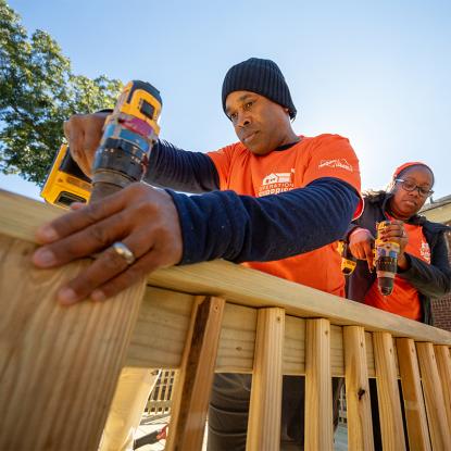 Two team depot volunteers assembling pieces of plywood