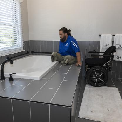 A veteran amputee looking at his new bathtub