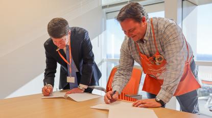 Two men signing a document