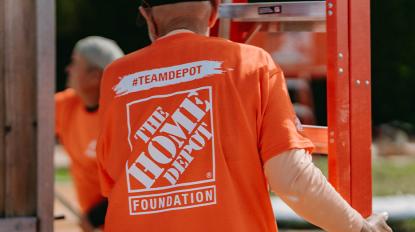 a team depot volunteer carrying a ladder